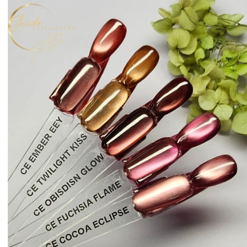 Vijf cateye gellak swatches op nageltips met een magnetisch cat-eye effect, zichtbaar in warme chocoladebruine, koper-, goud- en rosétinten waarbij het licht zich als een zachte glow over de nagel verplaatst.