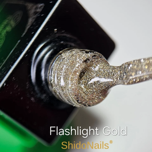 Close-up van de ShidoNails gellak flesopening en het penseel in de kleur flash gold, een transparant goud reflecterende tint.