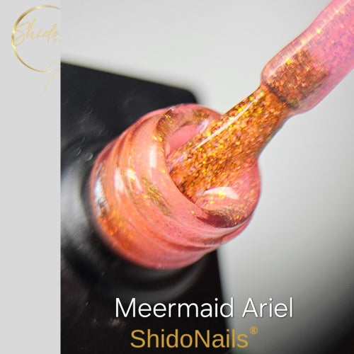 Textuur van ShidoNails Meermind Ariel gellak met een zachte koraalroze 'water' basis en sprankelende gouden glitters in de fles.