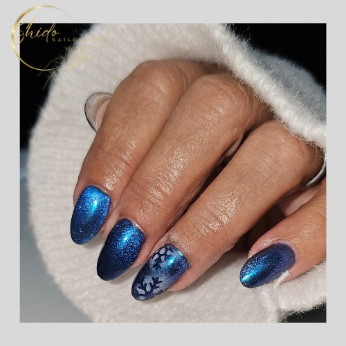 Diepblauwe cateye gellak Flame Jack van ShidoNails® met intense metallic glow en subtiele nailart op amandelvormige nagels, professioneel resultaat.