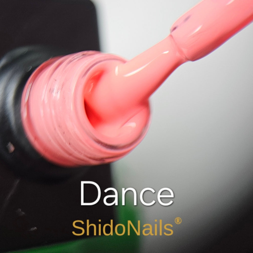 Close-up van de ShidoNails gellak kleur Dance, een levendige koraal-oranje of zalmkleurige lak op de kwast en in de flesopening.