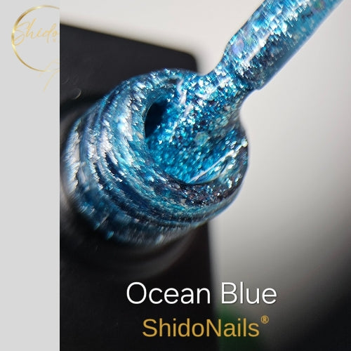 ShidoNails Ocean Blue glitter gellak close-up die de glinsterende, oceaankleurige blauwe glitterstructuur toont op het kwastje en in de opening van het flesje.